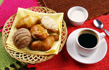 Café con canasta de pan dulce.