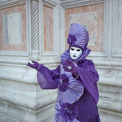 Person in Venetian costume attends Carnival of Venice.