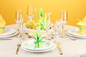 Table setting in green and yellow tones on color  background