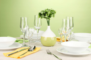 Table setting in green and yellow tones on color  background