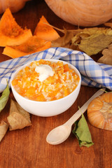 Useful pumpkin porridge in white plate on wooden table close-up