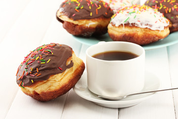 Tasty donuts on color plate on light wooden background