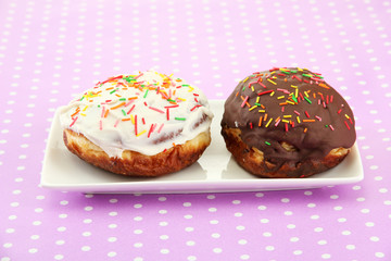 Tasty donuts on color plate on color background