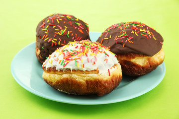 Tasty donuts on color plate on color background