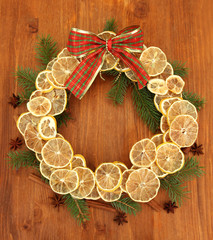 christmas wreath of dried lemons with fir tree and bow,