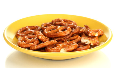Tasty pretzels in yellow plate isolated on white