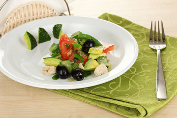 Tasty avocado salad in bowl  on wooden table close-up