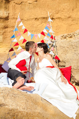 bride and groom posing on the beach by the sea