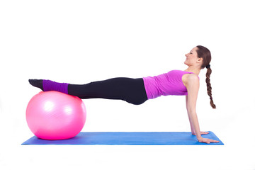 healthy young woman exercising with fit-ball in gym
