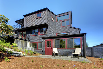 Fototapeta na wymiar Black wooden modern house with spring backyard.