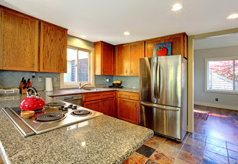 Kitchen with stove and  red tea pot.