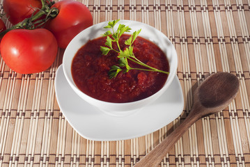 bowl of tomato sauce on wooden sticks tablecloth