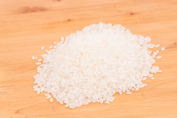 Pile of raw rice on wooden table