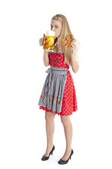 Stehende Frau im Dirndl trinkt Bier.