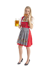 Blonde Frau im Dirndl beisst in Breze.