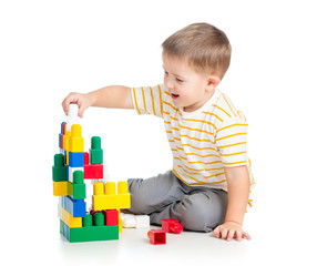 cheerful child boy playing with construction set over white back