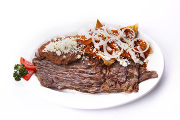 Chilaquiles en salsa roja con bistec. Comida mexicana