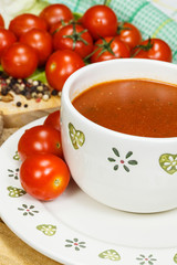 Tomato soup with tomatoes in background