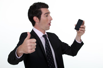 Thumbs up from a businessman with a cellphone
