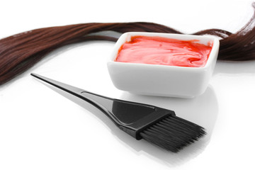 Bowl with hair dye and black brush on white background close-up