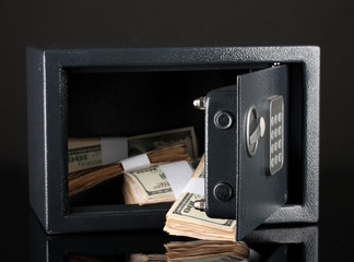 Money in open safe isolated on black