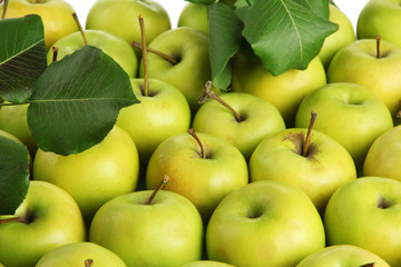 juicy apples with green leaves, close up