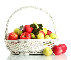 juicy apples with green leaves in basket, isolated on white