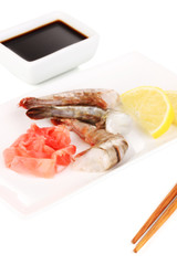 Prawn skewers on plate with ginger and lemon isolated on white