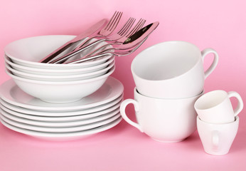 Clean white dishes on pink background