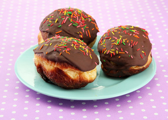 Tasty donuts on color plate on color background