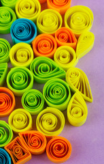 Colorful quilling on purple background close-up