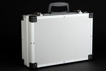 Silvery suitcase on black background