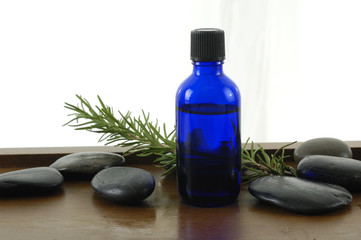 Obraz na płótnie Canvas bottle of aromatherapy oil and fresh green leaves
