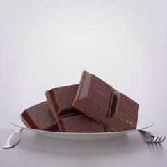 Chocolate bars stack on plate.