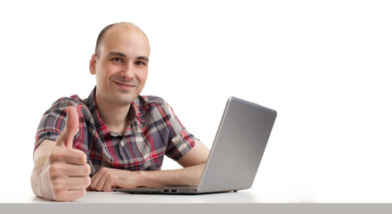 Smiling young guy using laptop computer.