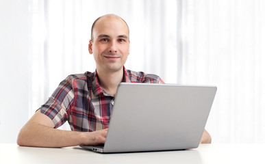Portrait of a happy young man using a laptop