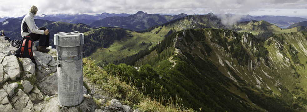 frau sitzt am gipfel des brecherspitz in spitzingsee