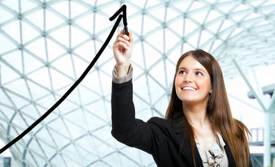 Businesswoman tracing a rising arrow: business growth