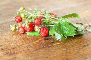 Wild strawberries on wooden background
