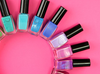 Group of bright nail polishes, on pink background