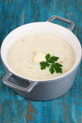 Mashed potatoes in saucepan on blue wooden table