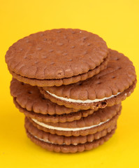 Chocolate cookies with creamy layer on yellow background