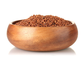 Raw buckwheat in wooden bowl isolated on white