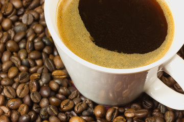 A cup of coffee with a coffe bean