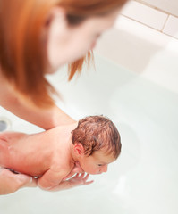 Fototapeta na wymiar Mother bathes newborn baby