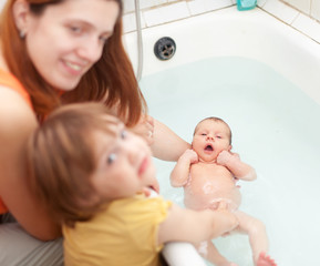 Mother bathes newborn baby