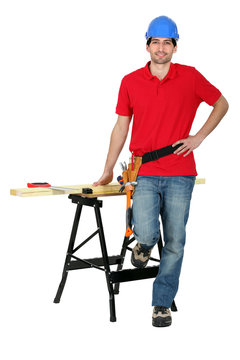 Man with wood, a workbench and saw
