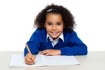 Young girl writing copying notes from the whiteboard