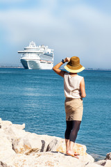 Woman with hat standing at sea