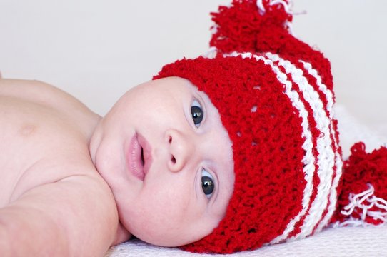 Portrait of the baby in a red knitted hat (3 months)